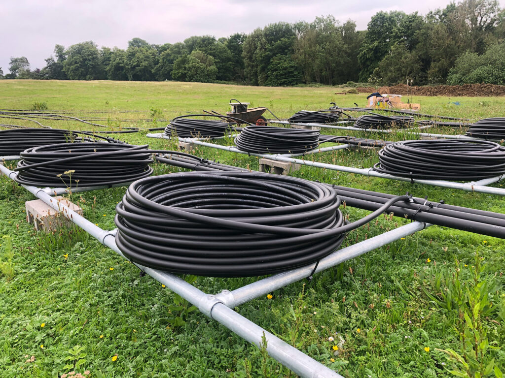 coils of pipes sitting on a metal frame system to be used as an array for a lake source heating system