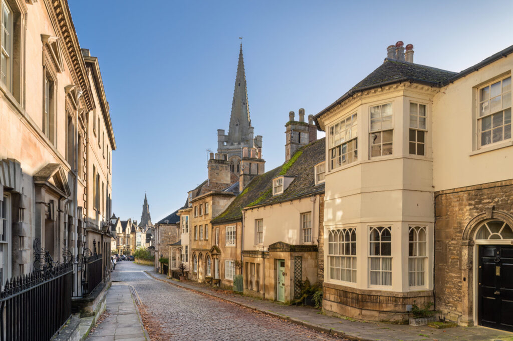 A narrow cobbled street in Stamford flanked by stone houses and cottages