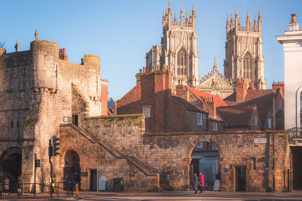 A view towards York Cathedral with a section of the castle walls and red brick properties in the foreground