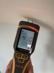 A wet moisture reading taken to a ceiling